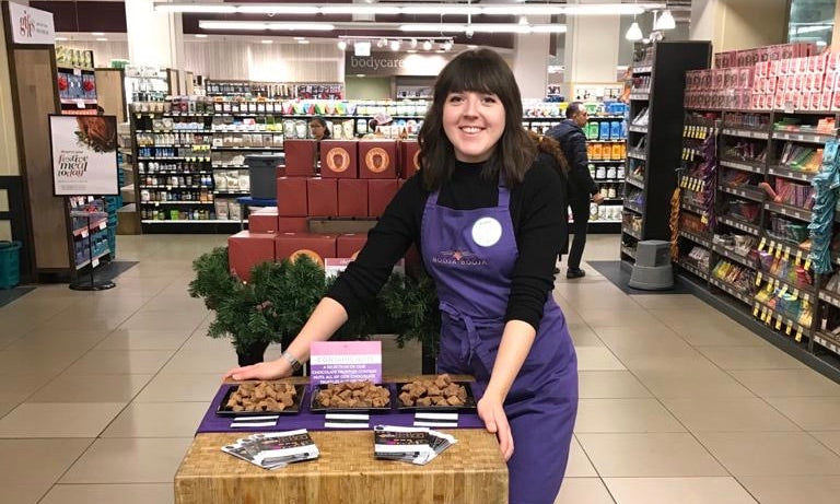 A member of the Booja-Booja team photographed in a department store with samples of Booja-Booja vegan chocolate truffles